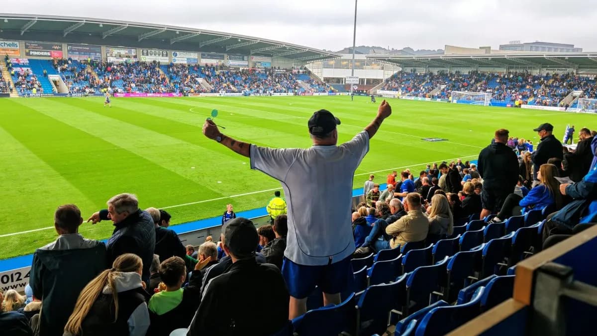 A fan cheering from the stands during a match